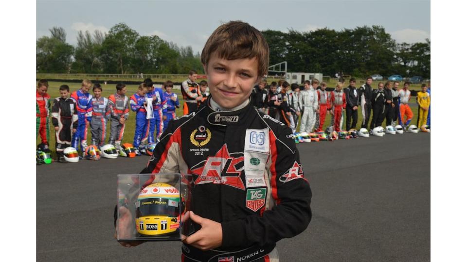 A young Lando Norris holding a trophy