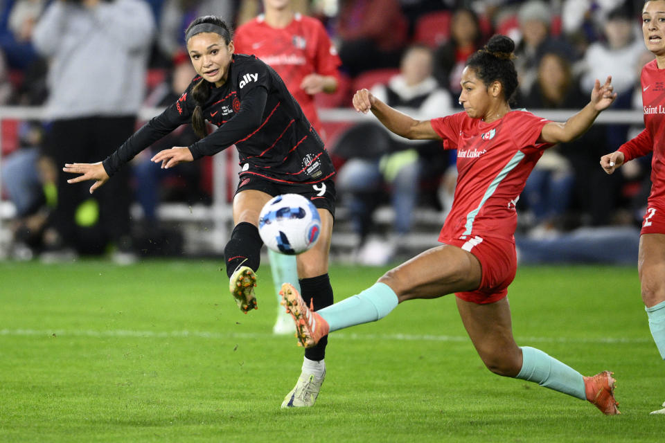 Portland Thorns FC forward Sophia Smith, left, kicks the ball against Kansas City Current defender Addisyn Merrick, right, during the first half of the NWSL championship soccer match, Saturday, Oct. 29, 2022, in Washington. (AP Photo/Nick Wass)