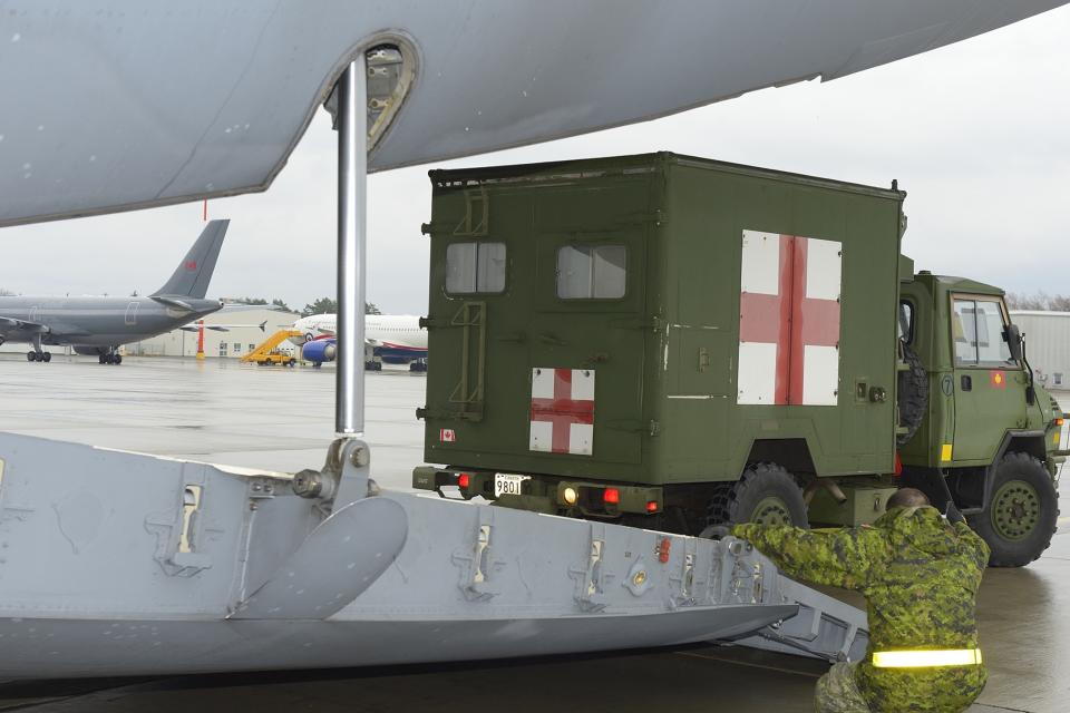 The advance party of the Disaster Assistance Response Team (DART) loads a military ambulance onto C177 Globemaster bound for Hawaii at Canadian Forces Base Trenton