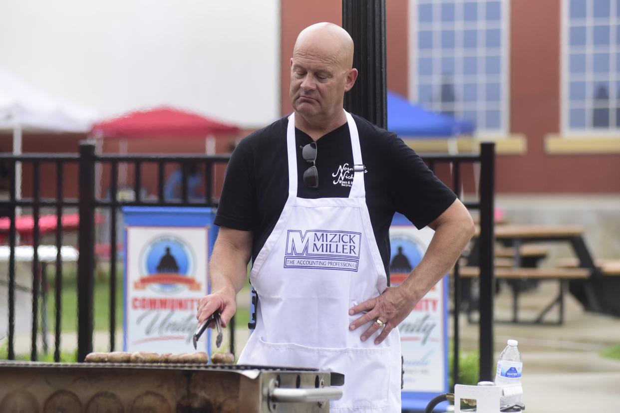 Jeff Norman of Norman's Niche turns a bratwurst during the 2021 South of the Square Block Rally at Schines Art Park in Bucyrus. The 2023 event will be on Friday, June 30.