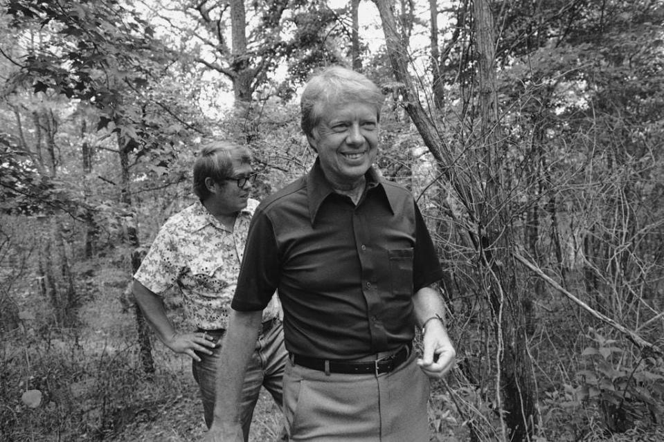 President Jimmy Carter and his younger brother Billy take a walk through the woods around their mother's pond house near Plains, Ga., June 1, 1977. The president paid a brief visit to his home town Tuesday.