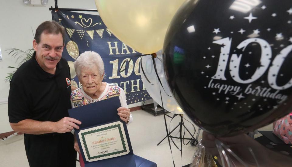 Port Orange Mayor Don Burnette and Elizabeth Parisi with the proclamation naming her Port Orange "Queen for the Day" in celebration of her 100th birthday, Wednesday, Oct. 11, 2023, during a celebration at the Adult Activity Center.