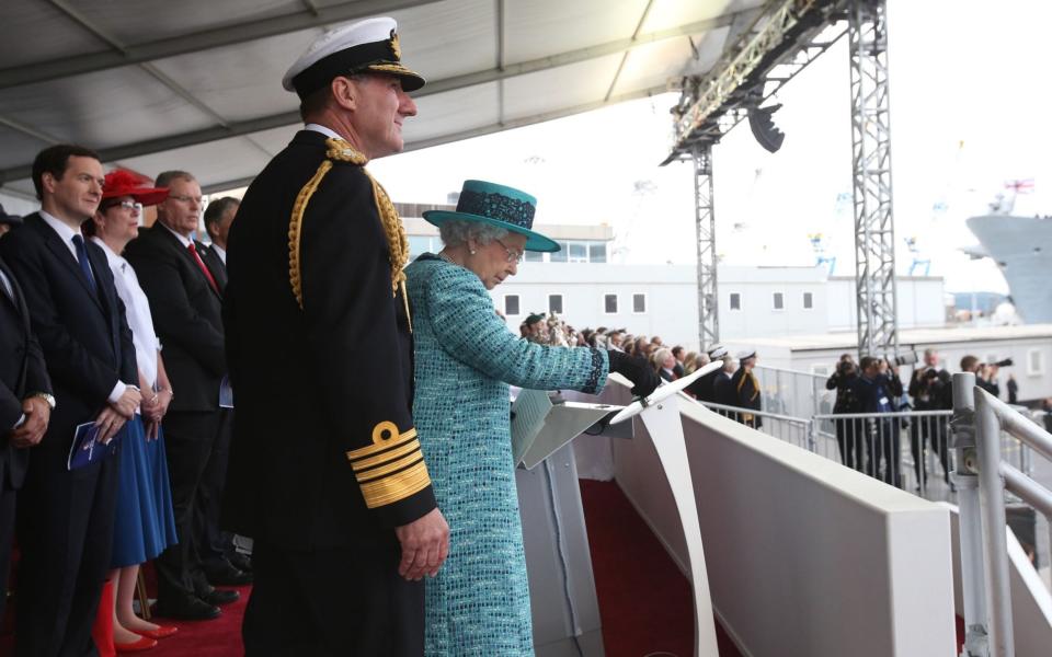 Queen Elizabeth II pressing the button to release the bottle of whisky at Rosyth Dockyard, Fife -  PA