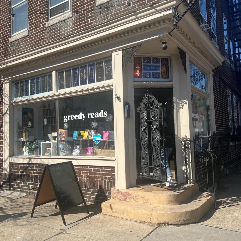 Quaint bookstore entrance with decorative door and sidewalk sign