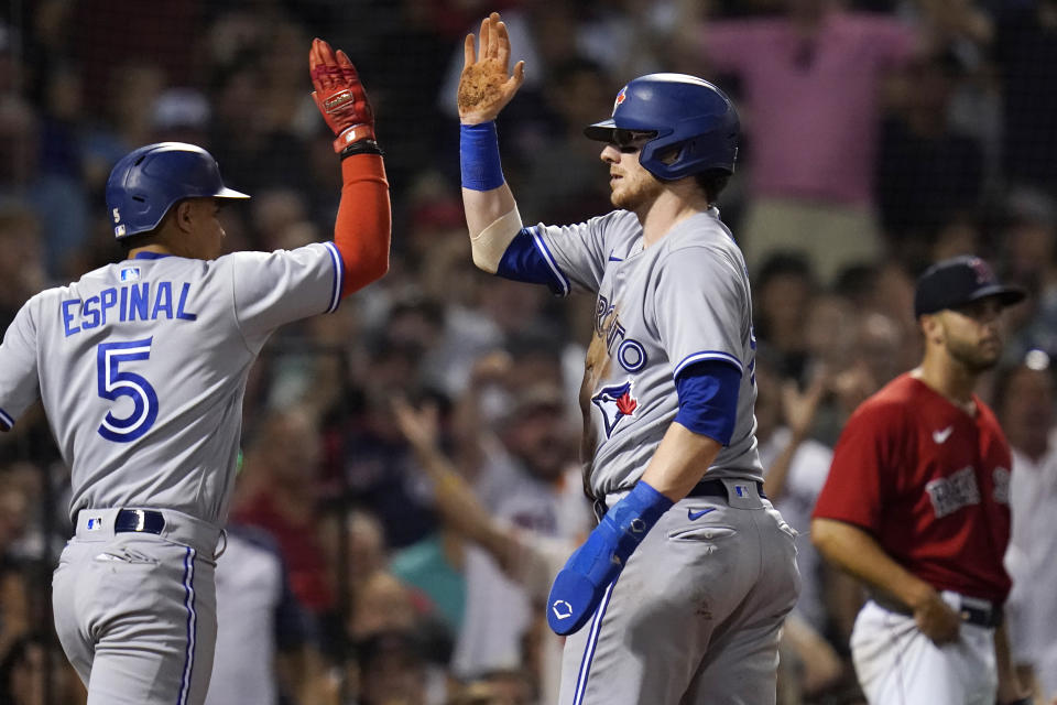 Toronto Blue Jays' Danny Jansen celebrates with Santiago Espinal (5) after scoring on a single by Vladimir Guerrero Jr. during the fourth inning of a baseball game, Thursday, Aug. 25, 2022, in Boston. (AP Photo/Charles Krupa)