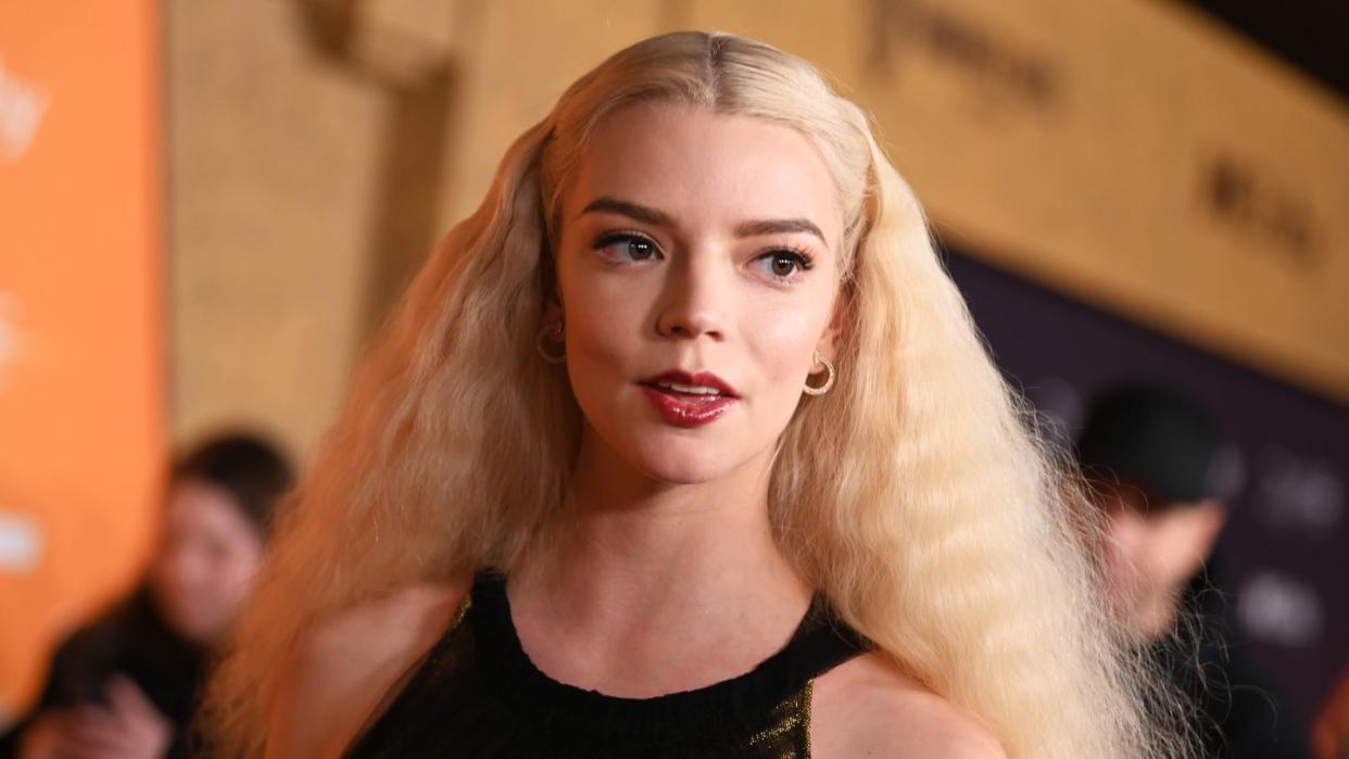 anya taylor joy looking right out of frame and smiling at a film premiere