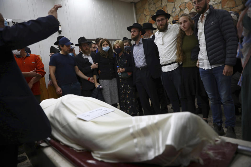 Mourners gather around the body of Eliyahu Kay, a 26-year-old immigrant to Israel from South Africa, during his funeral the day after he was killed when a Palestinian man opened fire in the Old City of Jerusalem, Monday, Nov. 22, 2021, in Jerusalem. (AP Photo/Oded Balilty)