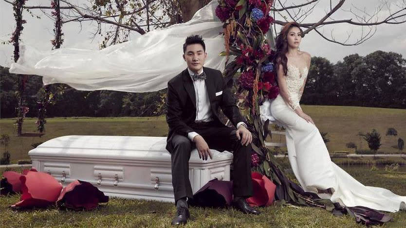 Bride and Groom Pose With Coffin