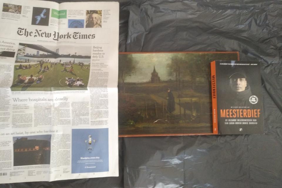 This image released by Arthur Brand Thursday, June 18, 2020, shows the stolen painting, center, by Dutch master Vincent van Gogh titled "The Parsonage Garden at Nuenen in Spring 1884", together with a copy of The New York Times dated May 30, 2020, and a book titled Master Thief. A Dutch art sleuth has received "proof-of-life" photos of a Vincent van Gogh painting stolen in late March from a Dutch museum in Laren, Netherlands, that was closed at the time because of the coronavirus. Brand, an art detective with a long track record of recovering stolen works, said Thursday that he received the photos recently and that they have been circulating in Mafia circles. (Arthur Brand via AP)