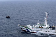 In this late May, 2019, photo provided by Japan Coast Guard, Japan Coast Guard patrol vessel approaches a North Korean fishing boat to warn them to leave the waters near Yamatotai, Japan. Coast Guard officials said Tuesday, June 18, they have forced more than 300 North Korean poachers out of Japan’s exclusive economic zone since May near Yamatotai rich with squid. (Japan Coast Guard via AP)