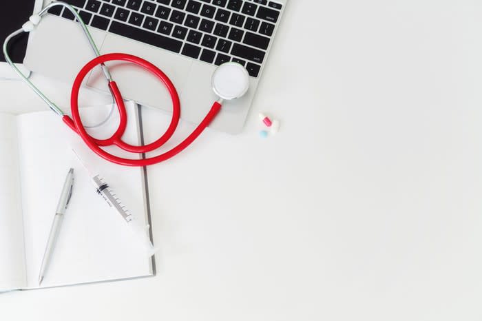 A stethoscope next to a laptop computer.