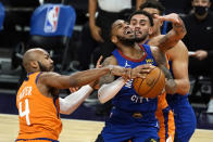 Denver Nuggets guard Monte Morris (11) drives between Phoenix Suns' Jevon Carter (4) and Abdel Nader during the first half of an NBA basketball game Friday, Jan. 22, 2021, in Phoenix. (AP Photo/Rick Scuteri)