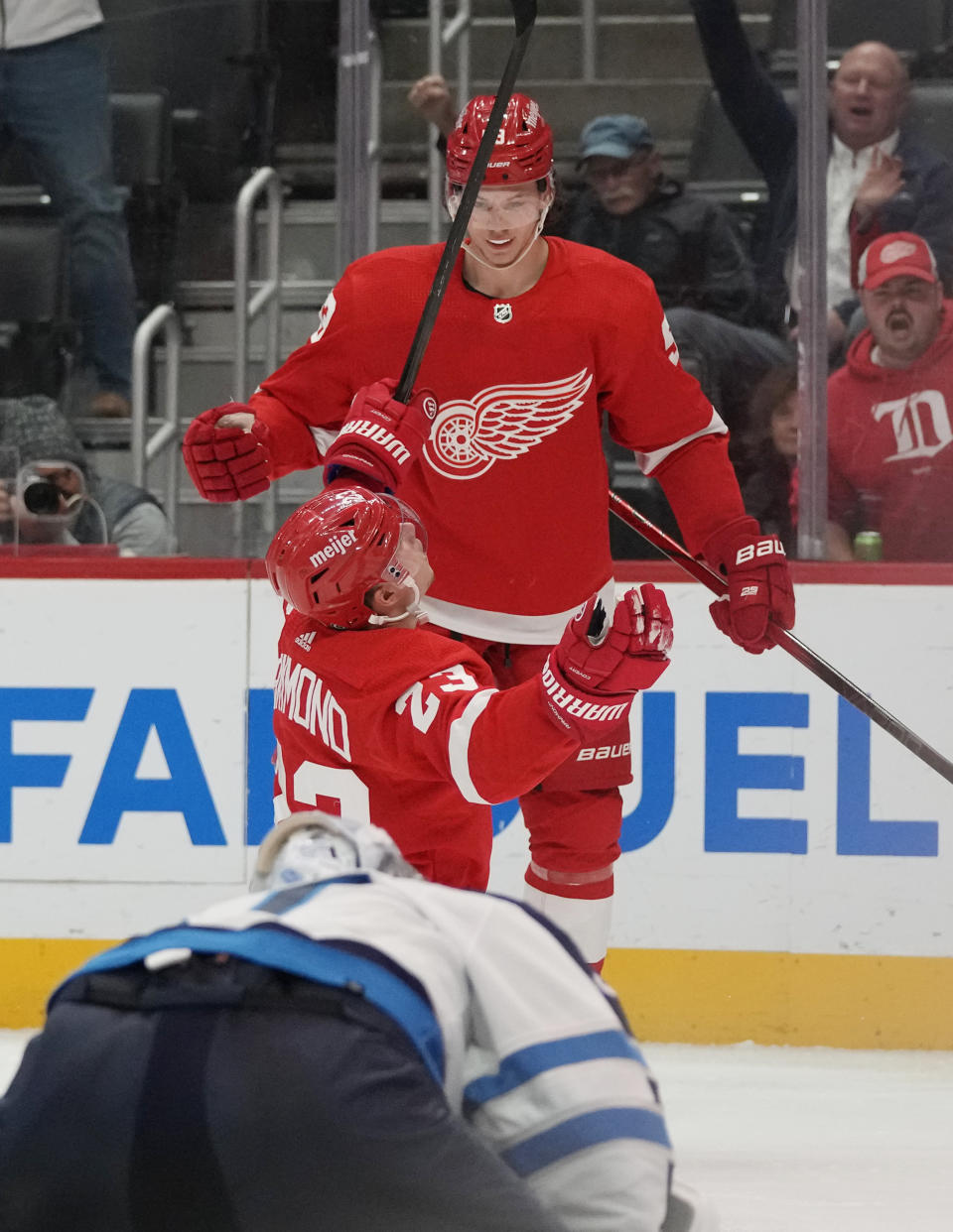 Detroit Red Wings left wing Lucas Raymond, center, reacts after scoring on Winnipeg Jets goaltender Connor Hellebuyck during the second period of an NHL hockey game, Thursday, Oct. 26, 2023, in Detroit. (AP Photo/Carlos Osorio)