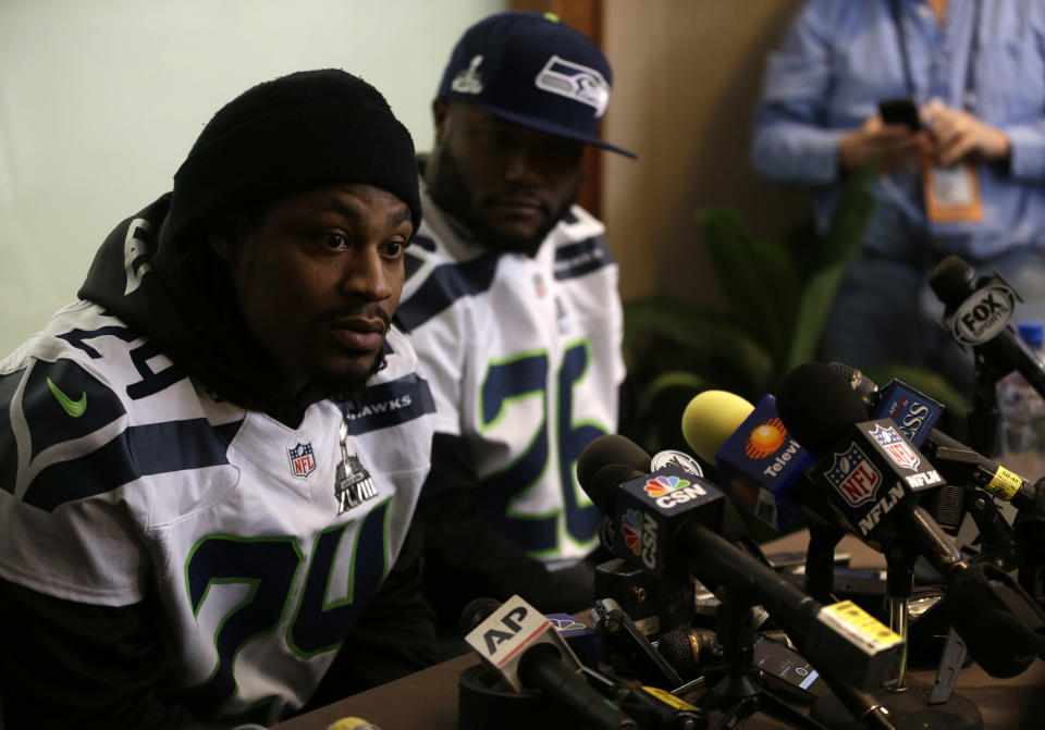 Seattle Seahawks running back Marshawn Lynch, left, answers questions along side teammate Michael Robinson during a media availability Thursday, Jan. 30, 2014, in Jersey City, N.J. The Seahawks and the Denver Broncos are scheduled to play in the Super Bowl XLVIII football game Sunday, Feb. 2, 2014. (AP Photo)