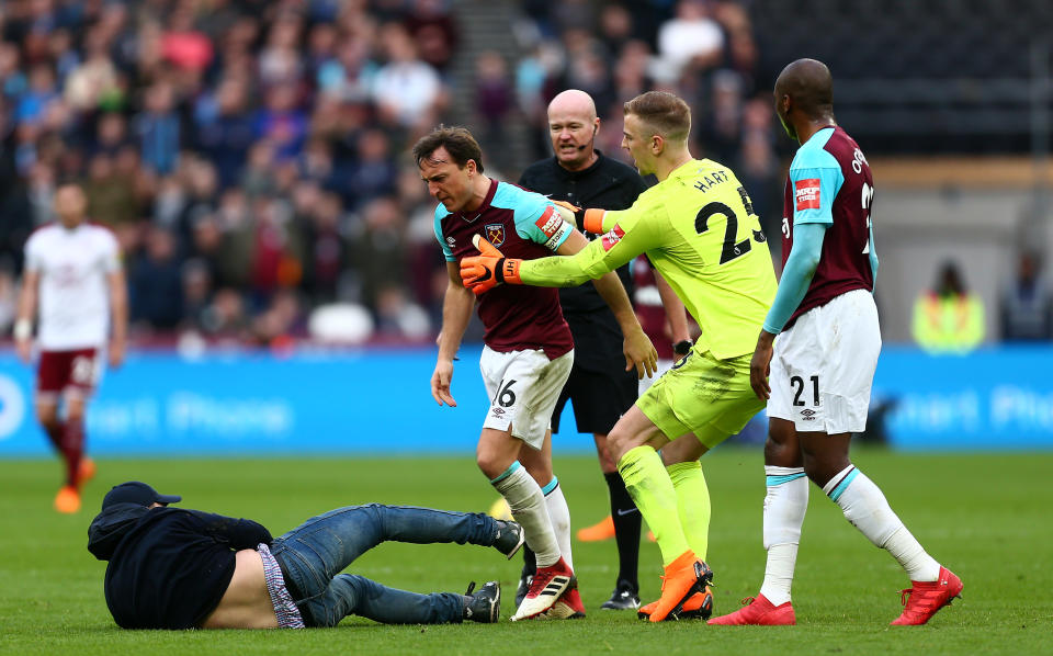 Mark Noble clashes with a West Ham fan who had invaded the pitch. (Getty)