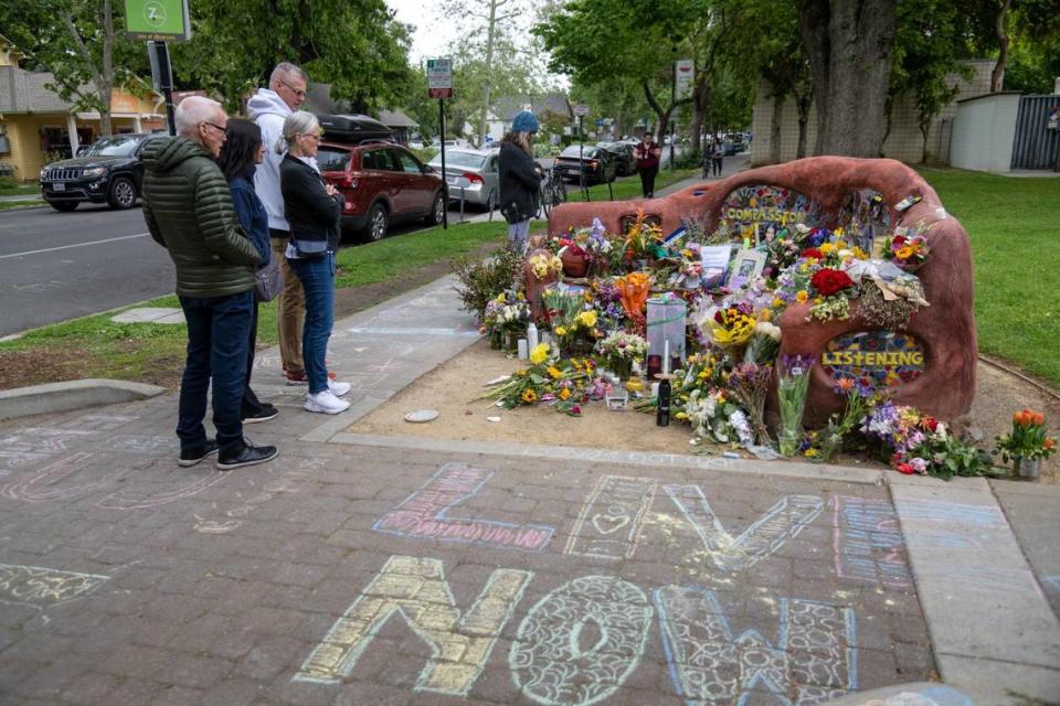 People view a memorial set up at the compassion bench in Davis on Monday, May 1, 2023, to honor David Henry Breaux, 50, who was found stabbed to death Thursday in Central Park.