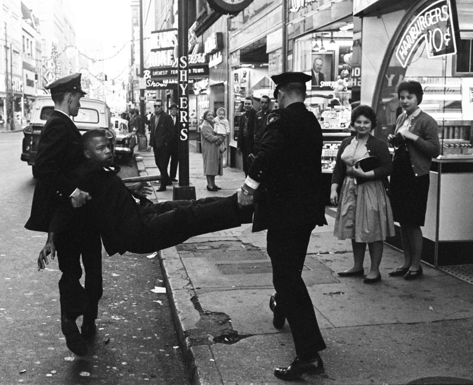 At a 1962 protest at Herschel's Tic Toc restaurant in Nashville, police officers carry the group's leader, John Lewis, to a waiting police van.