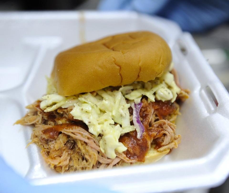 A pulled pork barbecue sandwich topped with house sauce and a pile of house Memphis-style slaw is served on the Beer Bones BBQ food truck on Thursday, March 28, 2024.