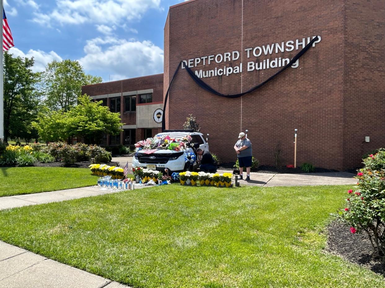 Retired Gloucester County Prosecutor's Office detective Tim Sullivan kneels while paying his respects to Deptford Office Bobby Shisler, who died Sunday from injuries sustained in the line of duty March 10.