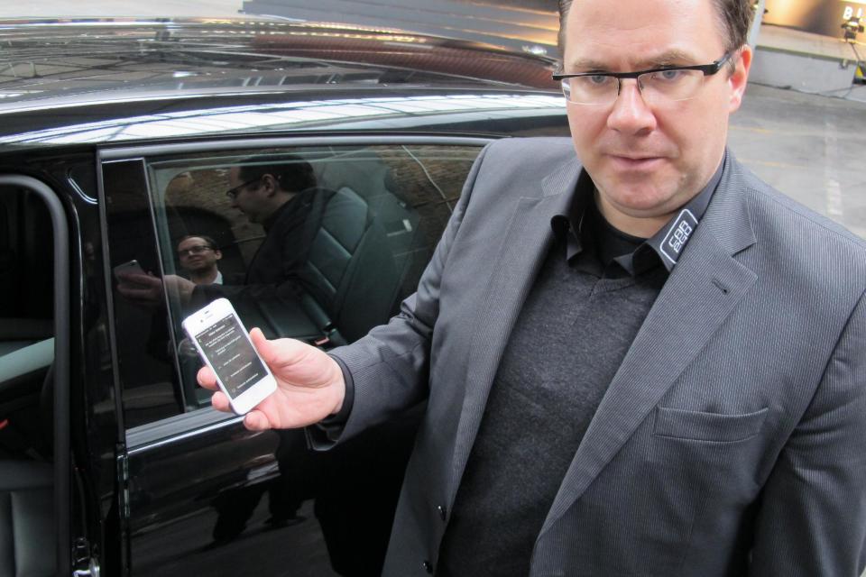 In this picture taken Tuesday, Feb. 18, 2014, Marcus Spickermann, managing director of Daimler Mobility Services GmbH, demonstrates the smartphone app for the German automaker's car sharing service Car2Go in Berlin, Germany. First they ignored it, then they jumped on board. Now some German automakers are switching gears to take car sharing from city streets to the Autobahn, a maneuver that’s being closely watched by others who wonder whether it could turn out to be a dead end for the industry. “We’re responding to requests from our customers, who say they occasionally need a bigger car that they can take outside the city boundaries,” said Spickermann. (AP Photo/Frank Jordans)