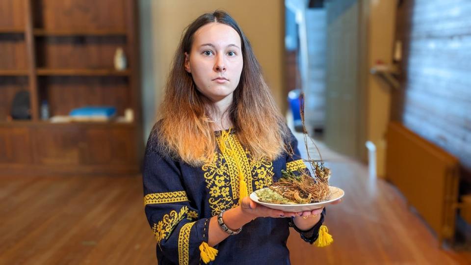 Tetiana Rymska, 18, holds a plate of foods that may have been eaten during the famine. Her grandmother told her about Holodomor for the first time, including a story about a sparrow that was cooked and shared by an entire family.  