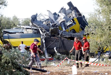 Rescuers work at the site where two passenger trains collided in the middle of an olive grove in the southern village of Corato, near Bari, Italy, July 12, 2016. REUTERS/Alessandro Garofalo