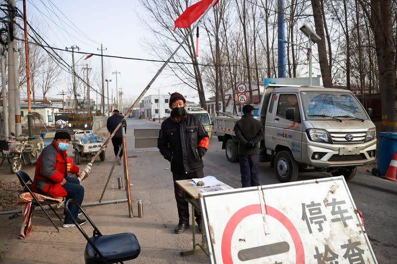 Volunteers stand at a checkpoint on a road leading into their village on the outskirts of Beijing