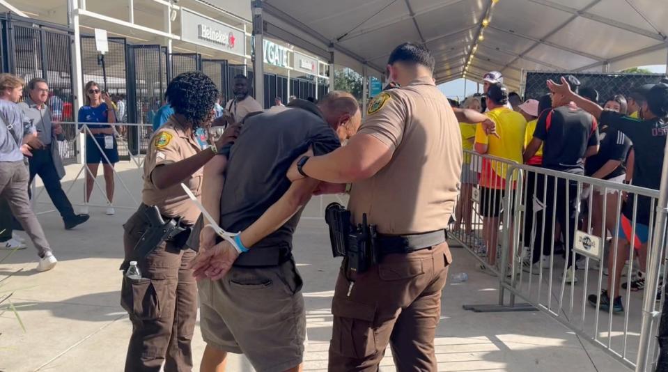 A man is detained by the police at Hard Rock Stadium in Miami (Reuters)