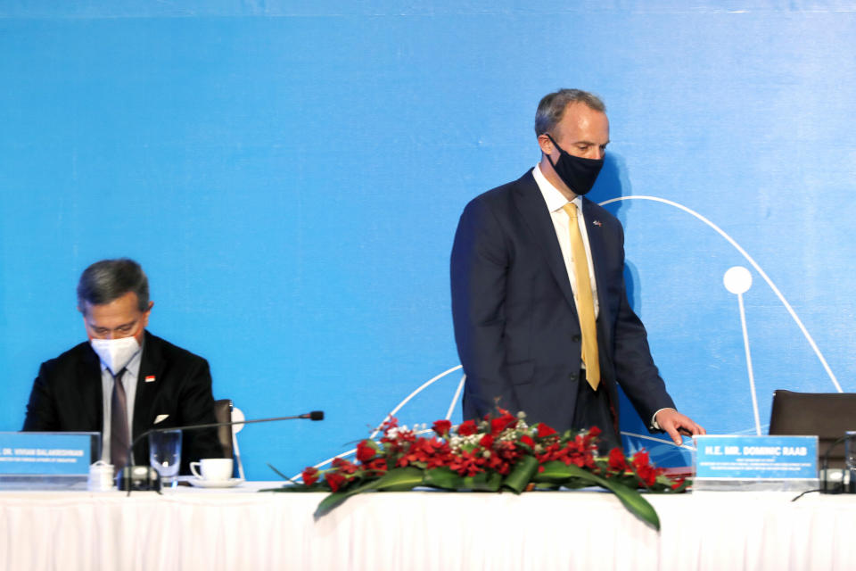 Singaporean Foreign Minister Vivian Balakrishnan, left, and Britain's Foreign Secretary Dominic Raab take seats for a meeting in Hanoi, Vietnam, Tuesday, June 22, 2021. The foreign ministers join with the rest of the ASEM delegates attending virtually via video conferencing to discuss cooperation between "Asia and Europe partnership in a changing world." (AP Photo/Hau Dinh)