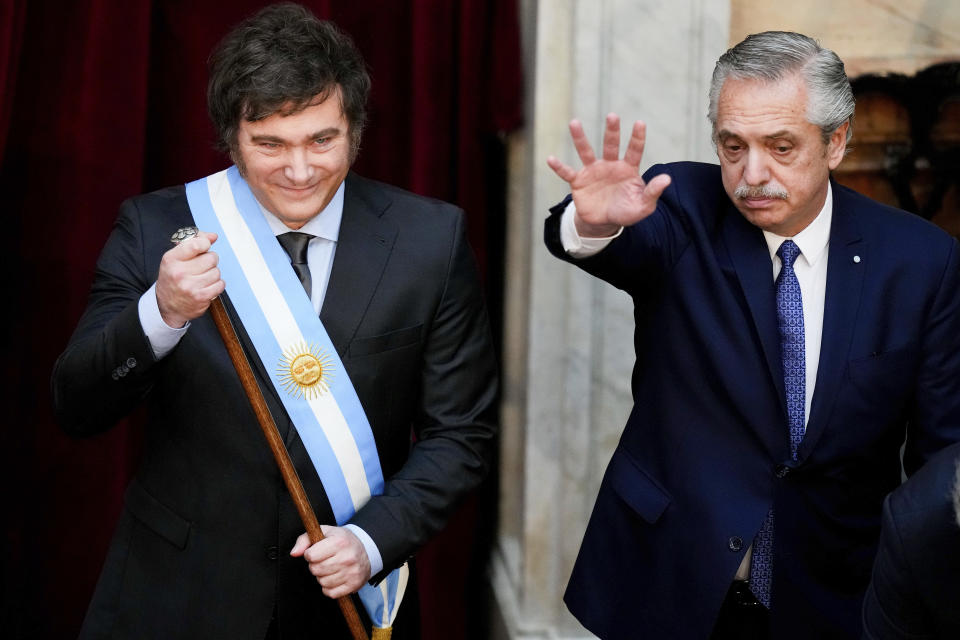 Argentina's incoming President Javier Milei holds the presidential cane after receiving it from outgoing President Alberto Fernandez, right, at the Congress in Buenos Aires, Argentina, Sunday, Dec. 10, 2023. (AP Photo/Natacha Pisarenko)