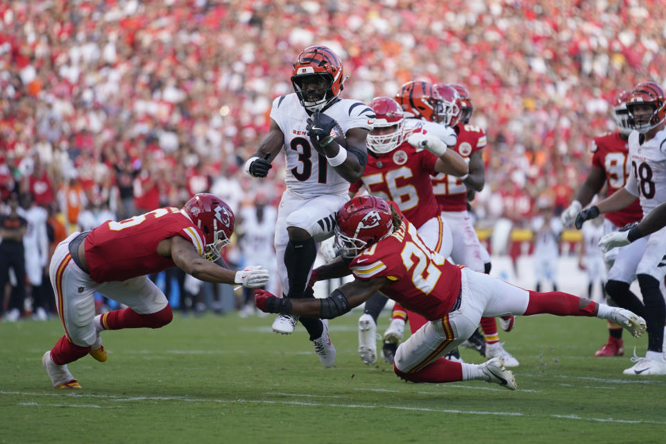 Cincinnati Bengals Zack Moss (31) runs with the ball as Kansas City Chiefs safety Bryan Cook, left, and safety Justin Reid (20) defend during the second half of an NFL football game Sunday, Sept. 15, 2024, in Kansas City, Mo. (AP Photo/Ed Zurga)