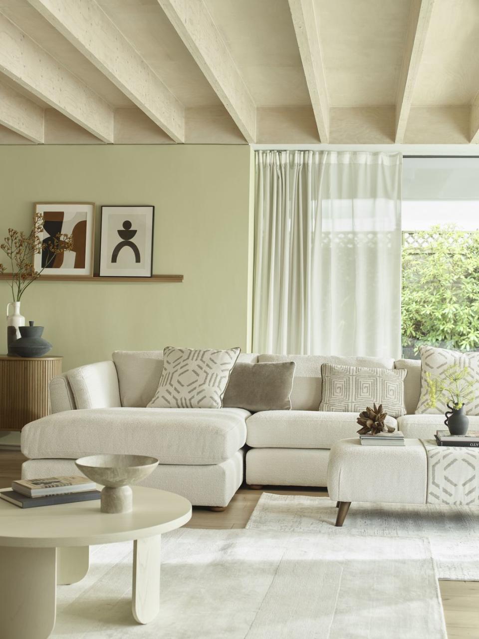 a green living room with a white couch and a white coffee table
