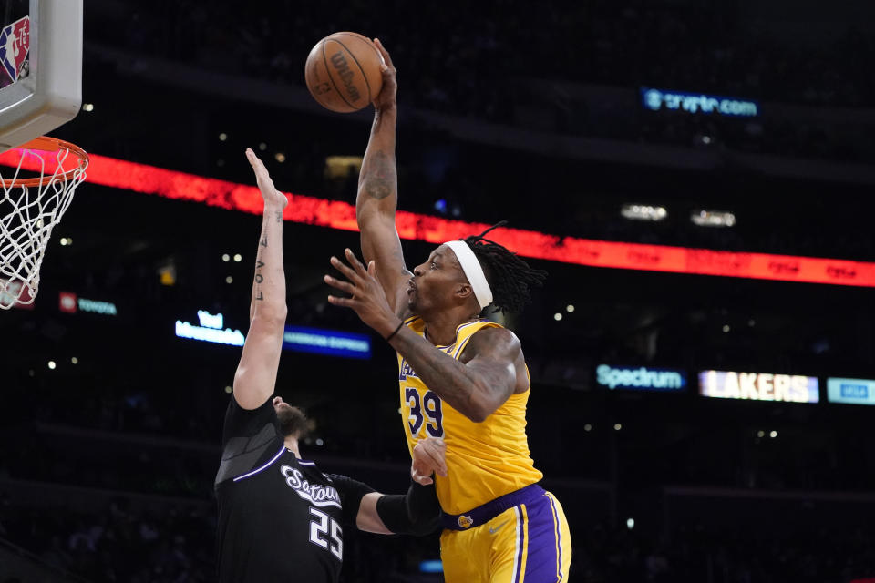 Los Angeles Lakers center Dwight Howard (39) goes up for a dunk as Sacramento Kings center Alex Len (25) defends during the first half of an NBA basketball game Tuesday, Jan. 4, 2022, in Los Angeles. (AP Photo/Marcio Jose Sanchez)