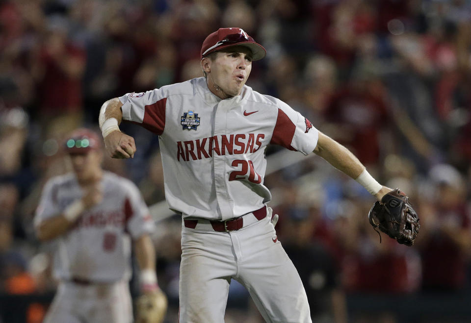 FILE - Arkansas second baseman Carson Shaddy celebrates after tagging out Oregon State's Zak Taylor trying to advance on a base hit during the seventh inning of Game 1 of the NCAA College World Series baseball finals in Omaha, Neb., Tuesday, June 26, 2018. Arkansas did something rare during the 2017-18 and 2018-19 seasons: It watched its baseball and softball teams both reach the NCAA tournament. The similarities end there. (AP Photo/Nati Harnik, File)