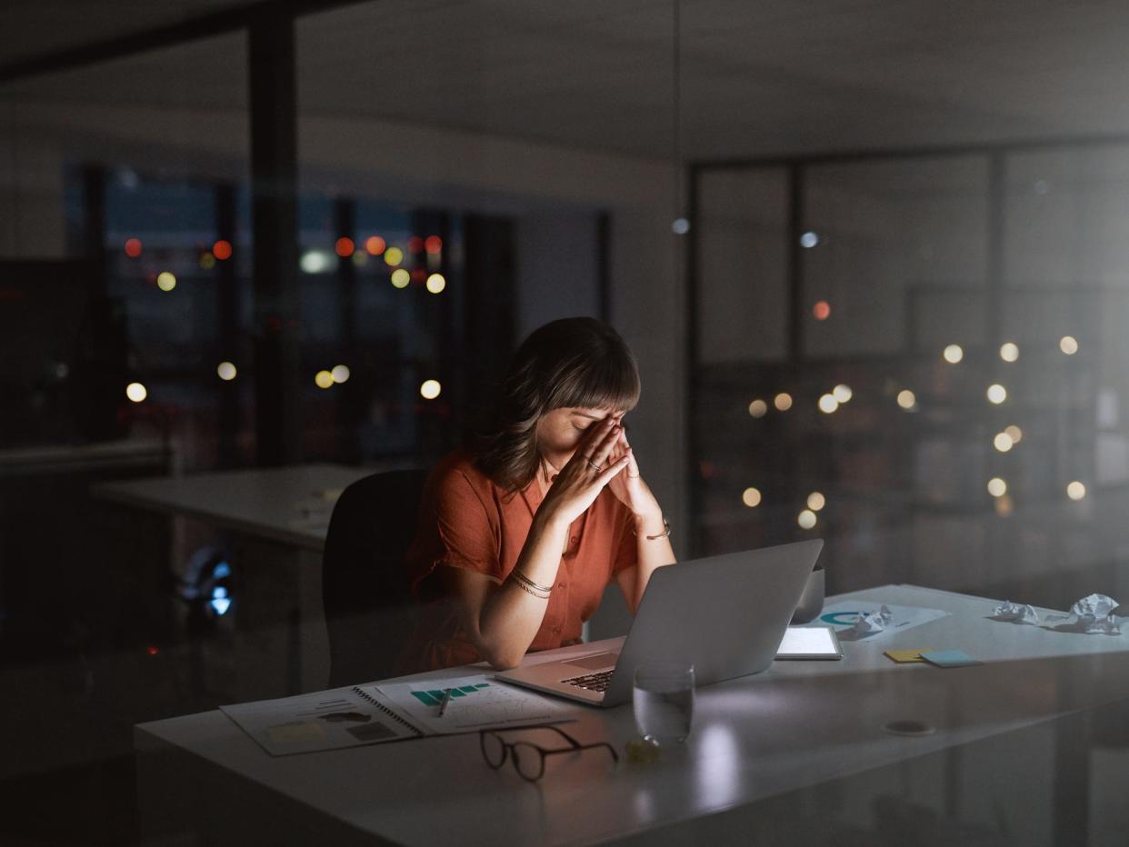 stressed woman working in office at night