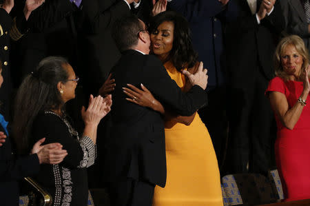 U.S. first lady Michelle Obama hugs Connecticut Governor Dannel Malloy as she arrives in the first lady's box for U.S. President Barack Obama's State of the Union address to a joint session of Congress in Washington, January 12, 2016. REUTERS/Jonathan Ernst