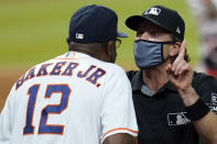 Umpire Chris Guccione, right, talks to Houston Astros manager Dusty Baker (12) after both benches emptied onto the field after the sixth inning of a baseball game against the Los Angeles Dodgers Tuesday, July 28, 2020, in Houston. (AP Photo/David J. Phillip)