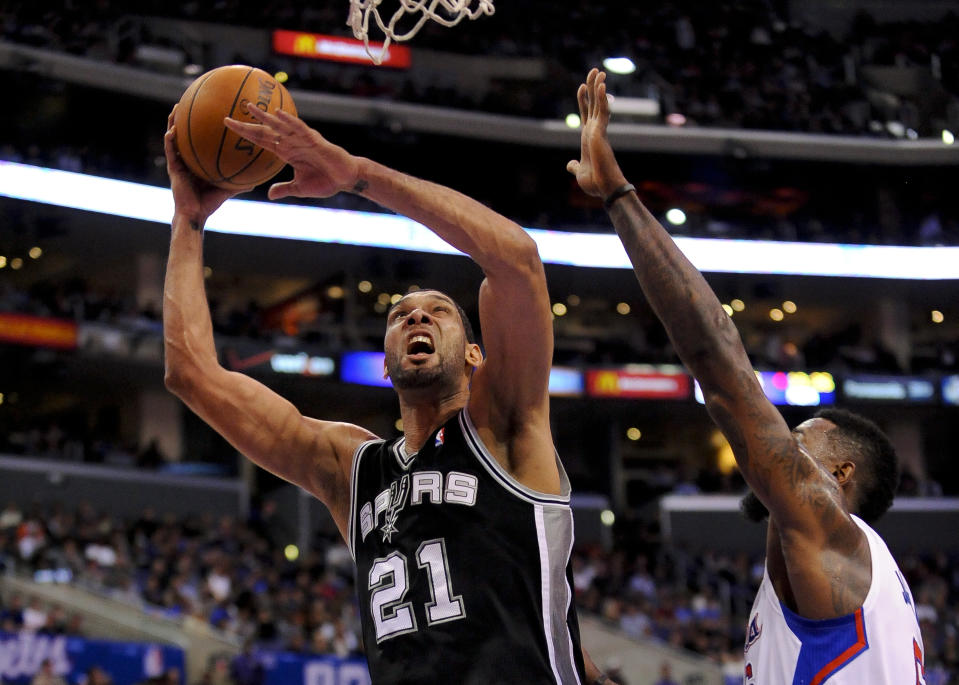 San Antonio Spurs forward Tim Duncan (21) gets by Los Angeles Clippers center DeAndre Jordan (6) for a basket in the first half of a NBA basketball game, Tuesday, Feb. 18, 2014, in Los Angeles.(AP Photo/Gus Ruelas)