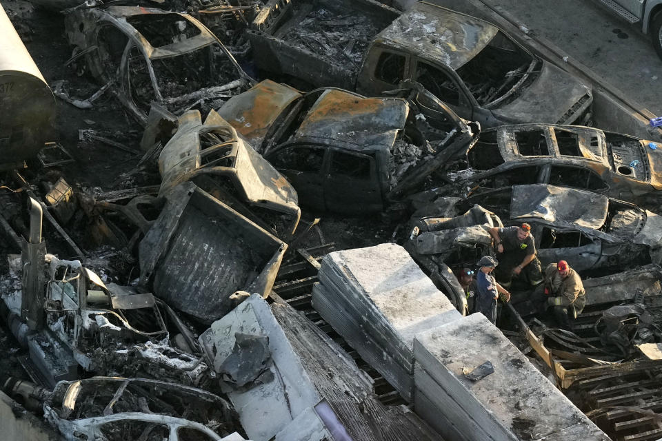 Responders stand amid wreckage in the aftermath of a multi-vehicle pileup on Interstate 55 in Manchac, La., on Oct. 23, 2023. A "superfog" of smoke from south Louisiana marsh fires and dense morning fog caused multiple traffic crashes involving scores of cars. (AP Photo/Gerald Herbert)