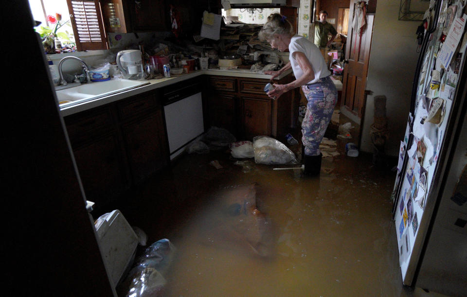 Nancy McBride collects items from her flooded kitchen as she returned to her home on Sept. 1, 2017, for the first time since floods caused by Hurricane Harvey inundated Houston.<i></i> (Photo: Rick Wilking / Reuters)