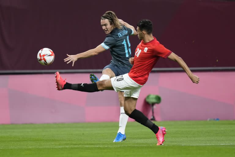 El argentino Pedro De La vega golpea el balón desafiado por el egipcio Ahmed Fotouh durante un partido de fútbol masculino en los Juegos Olímpicos de Verano de 2020, el domingo 25 de julio de 2021, en Sapporo, Japón.