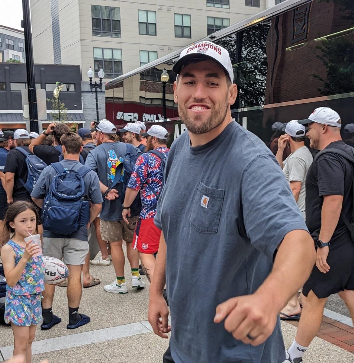 New England Free Jacks club captain Josh Larsen fist bumps a fan to celebrate the team's championship victory. Crowds met the returning champions at Kilroy Square in Quincy on Sunday, July 9.