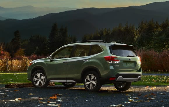 A rear-three-quarter view of a green 2019 Subaru Forester.