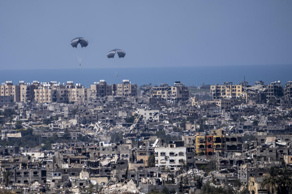 Parachutes airdrops humanitarian aid over the northern Gaza Strip, as seen from southern Israel, Tuesday, March 26, 2024. (AP Photo/Ariel Schalit)