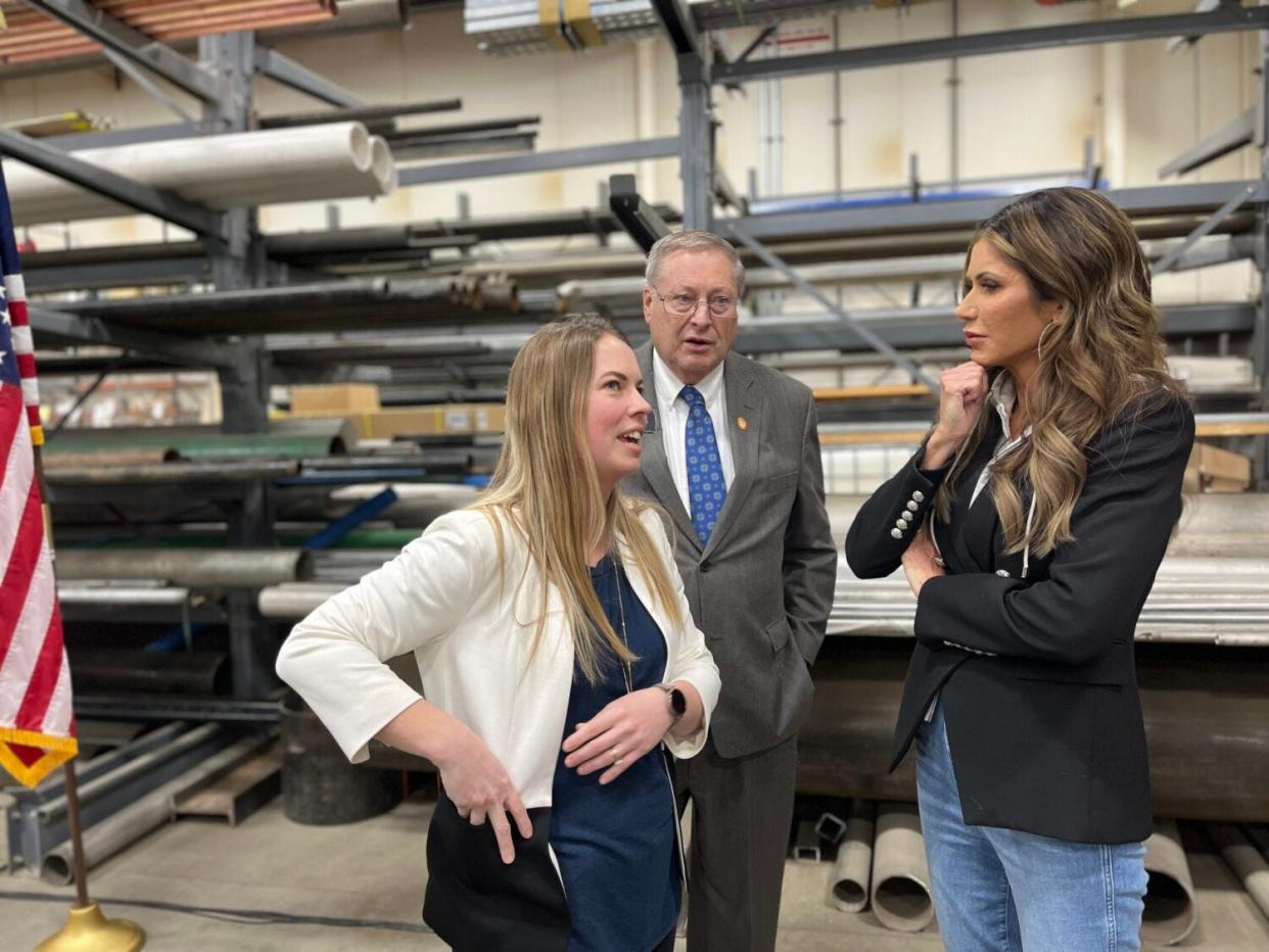 Gov. Kristi Noem, right, talks with Tamara Carns, a teacher from North Dakota now working in Yankton, and state Sen. Jim Stalzer, R-Sioux Falls, during a bill signing March 1, 2023, at Midwestern Mechanical in Sioux Falls.
