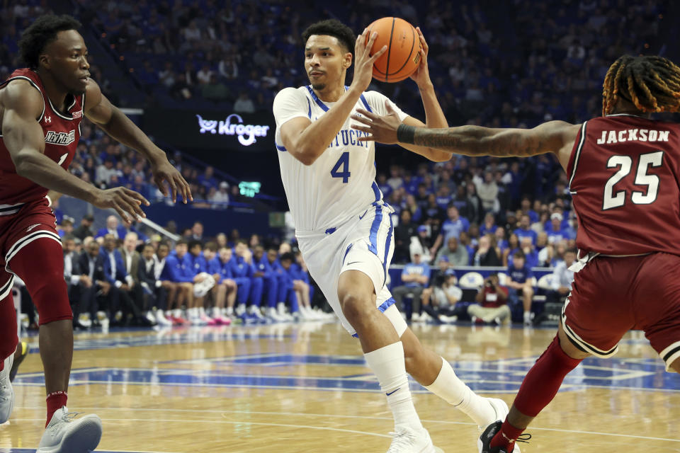 Kentucky's Tre Mitchell (4) drives between New Mexico State's Kaosi Ezeagu, left, and Clarence "Monzy" Jackson during the first half of an NCAA college basketball game in Lexington, Ky., Monday, Nov. 6, 2023. (AP Photo/James Crisp)