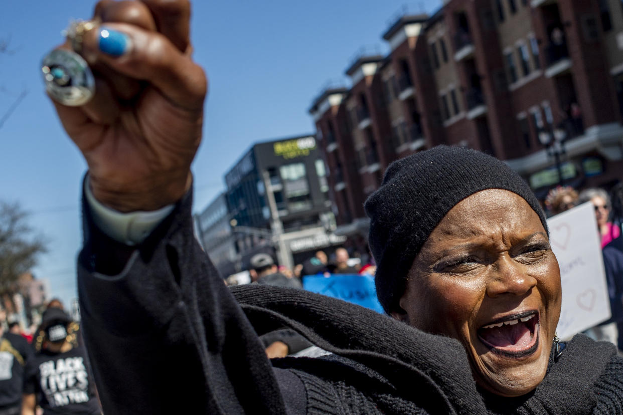 Maxine Cain of Lansing, Mich., throws her fist in the air as she shouts out "No justice, no peace," while marching alongside others wearing all black in support of the Lyoya family on Thursday, April 21, 2022 at a rally at the Capitol in Lansing, Mich. to demand justice in the police shooting that took the life of Congolese immigrant Patrick Lyoya. (Jake May/The Flint Journal via AP)