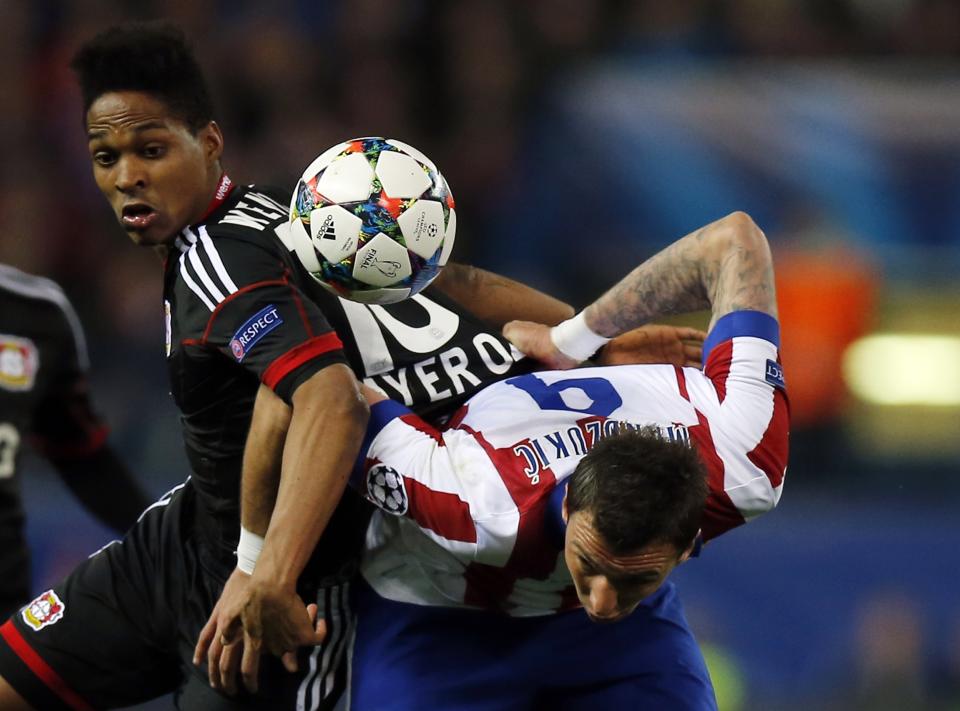 Atletico Madrid's Mario Mandzukic (R) and Bayer Leverkusen's Wendell fight for the ball during their Champions League round of 16 second leg soccer match at Vicente Calderon stadium in Madrid March 17, 2015. REUTERS/Sergio Perez (SPAIN - Tags: SPORT SOCCER)