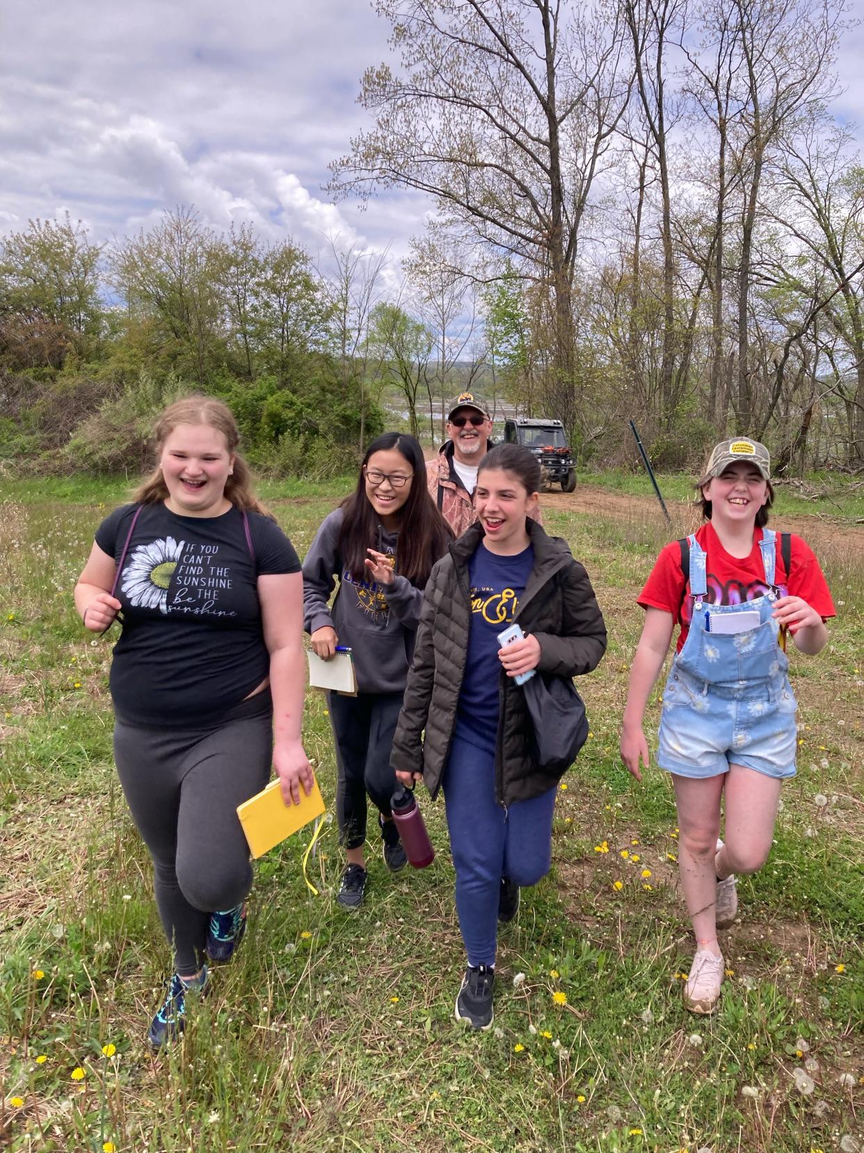Wooster Edgewood Middle School seventh graders, from left, Allie Greenwald, Claire Jeon, Willow Fetty and Rae Phillips head out into a field at Killbuck Marsh Wildlife Area in search of a story under the guidance of Daily Record outdoor correspondent Art Holden, back.