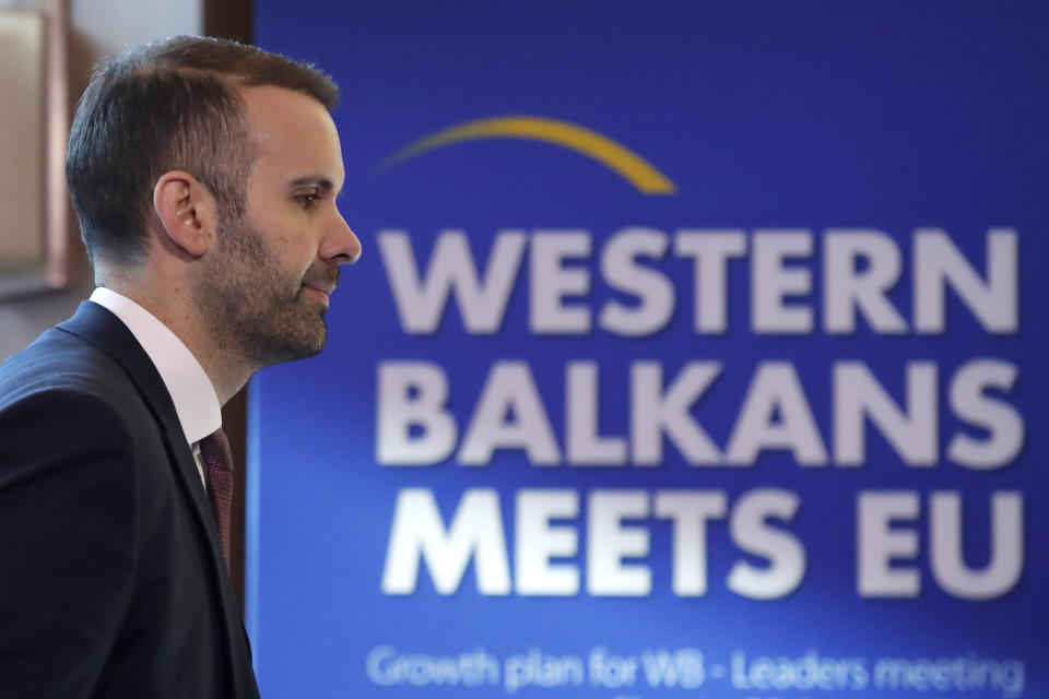 Montenegro's Prime Minister Milojko Spajic walks past a banner during the Western Balkans meets EU, Growth plan for WB - Leaders meeting, in Skopje, North Macedonia, on Monday, Jan. 22, 2024. (AP Photo/Boris Grdanoski)